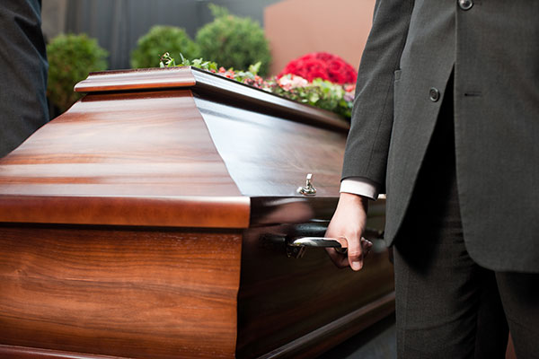 homme-portant-un-cercueil-en-bois-foncé